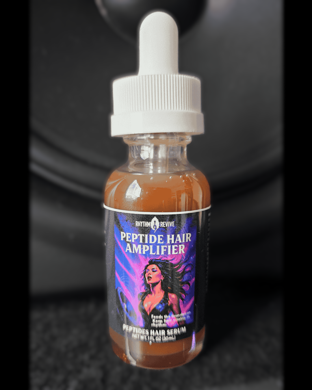 A small amber bottle of Rhythm & Revive Peptide Hair Amplifier serum with a dropper cap, featuring a label that shows a stylized woman with flowing hair against a purple and blue background.