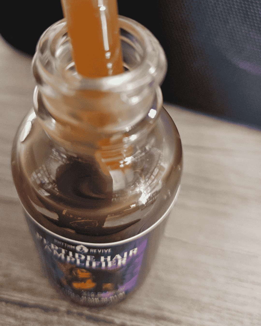 open bottle of Peptide hair amplifier on wood table