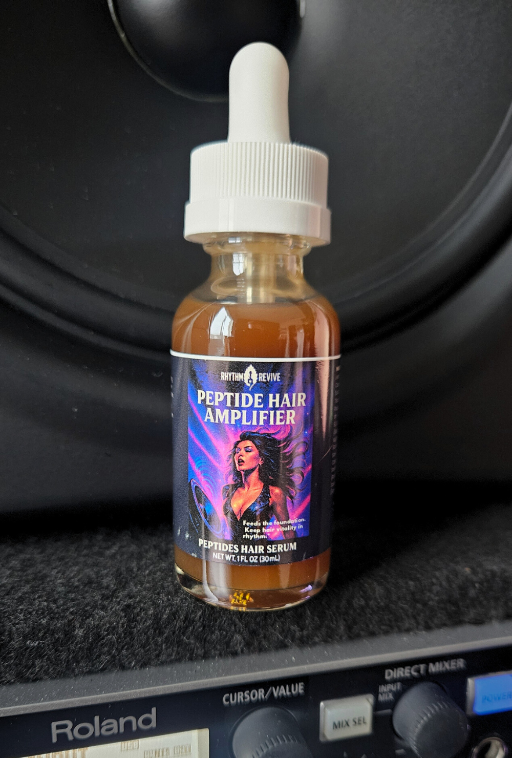 Bottle of Peptide Hair Amplifier serum on a Roland audio equipment background