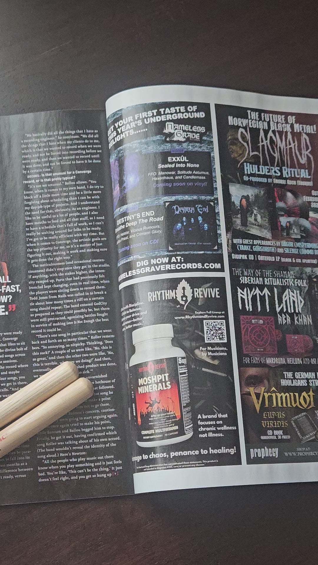 Load video: Metal music playing over speakers with camera footage opening a Decibel magazine to a page with MoshPit Minerals, then a hand with the horn is shown.