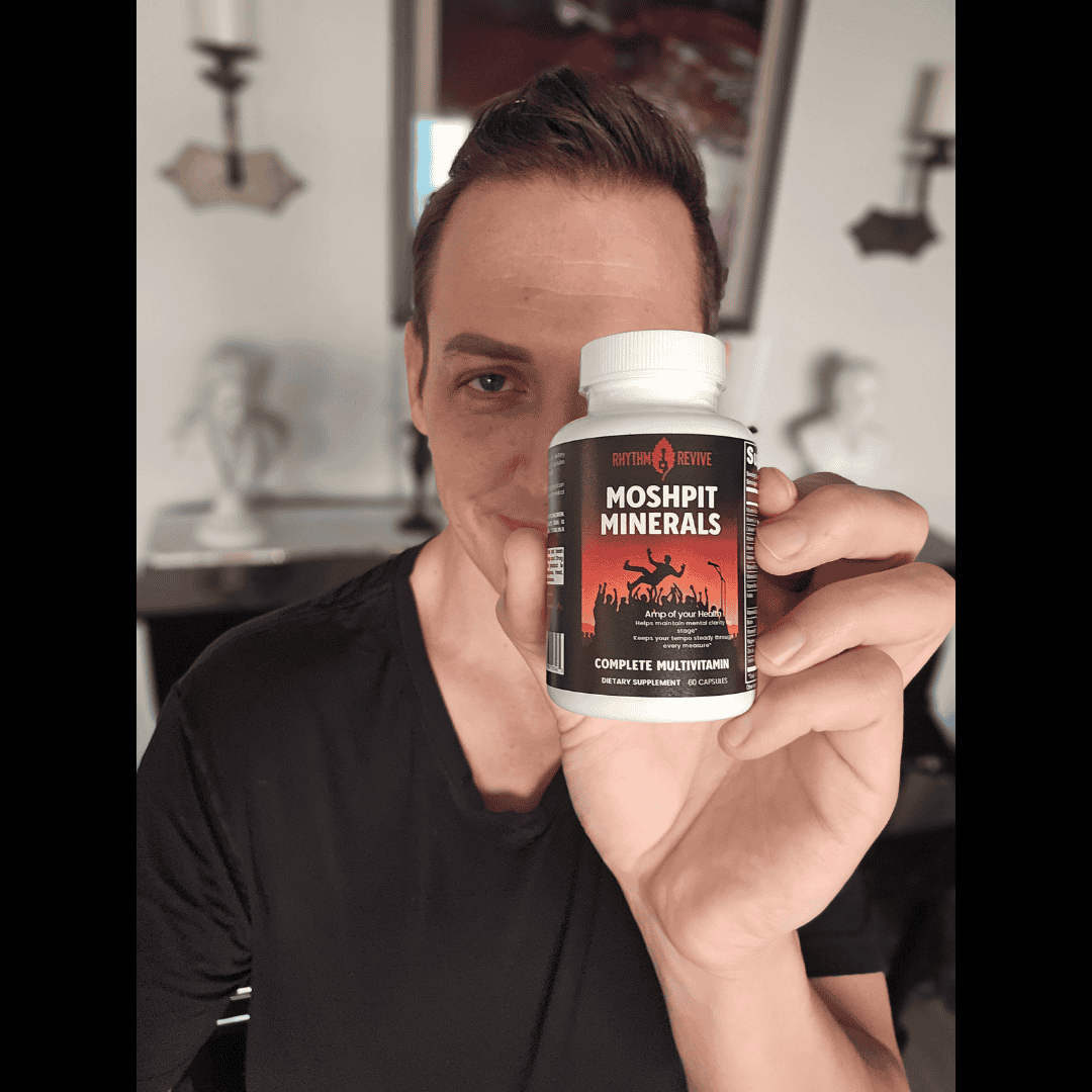 Person holding a supplement bottle labeled 'Moshpit Minerals' in a room.