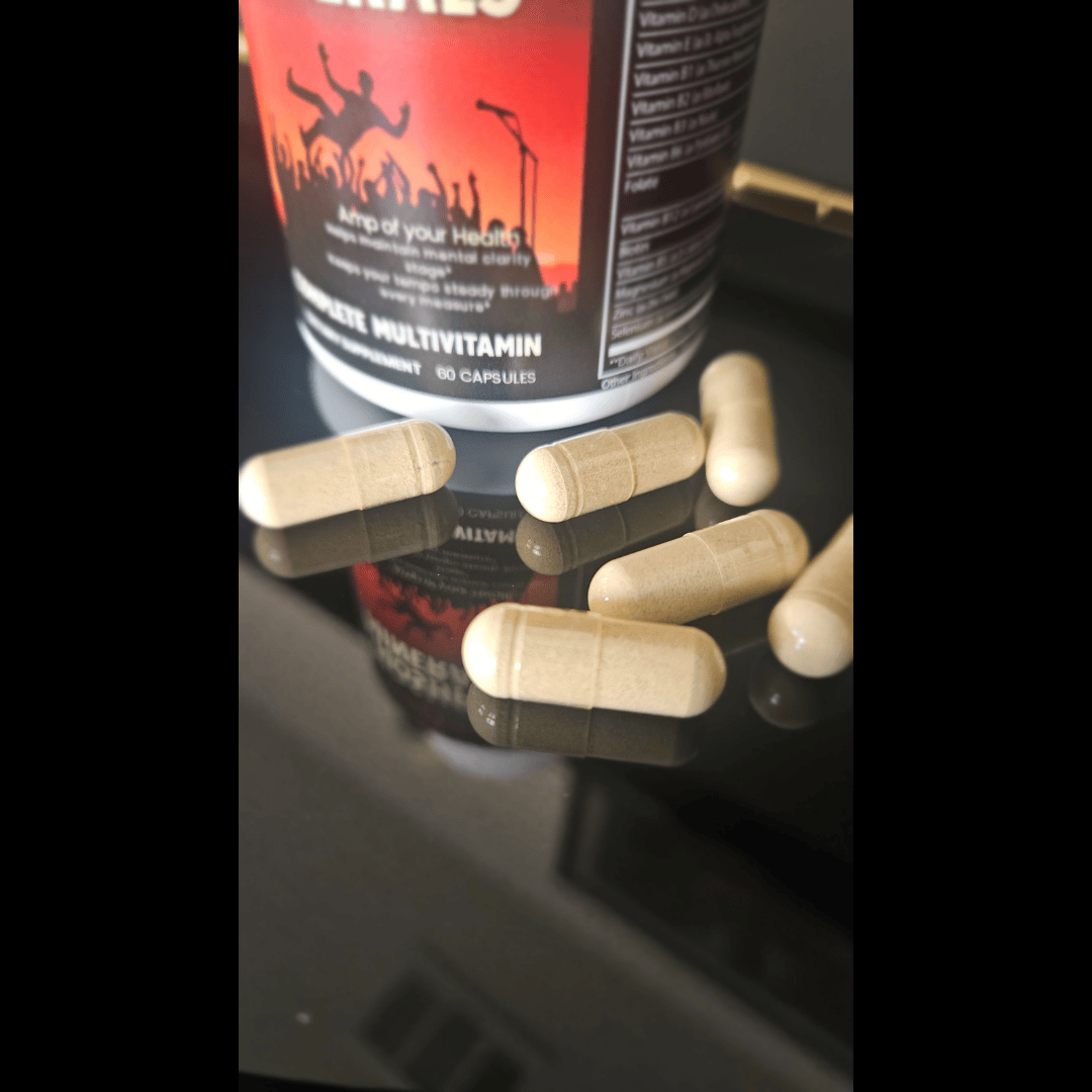 Multivitamin capsules on a reflective surface with a multivitamin container in the background.