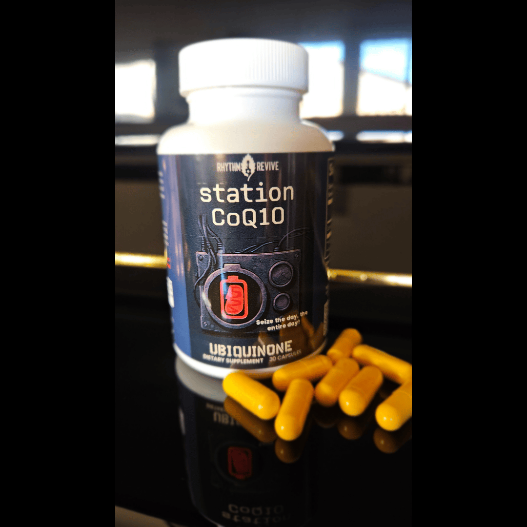 Bottle of station CoQ10 supplement with yellow capsules on a piano black reflective surface.