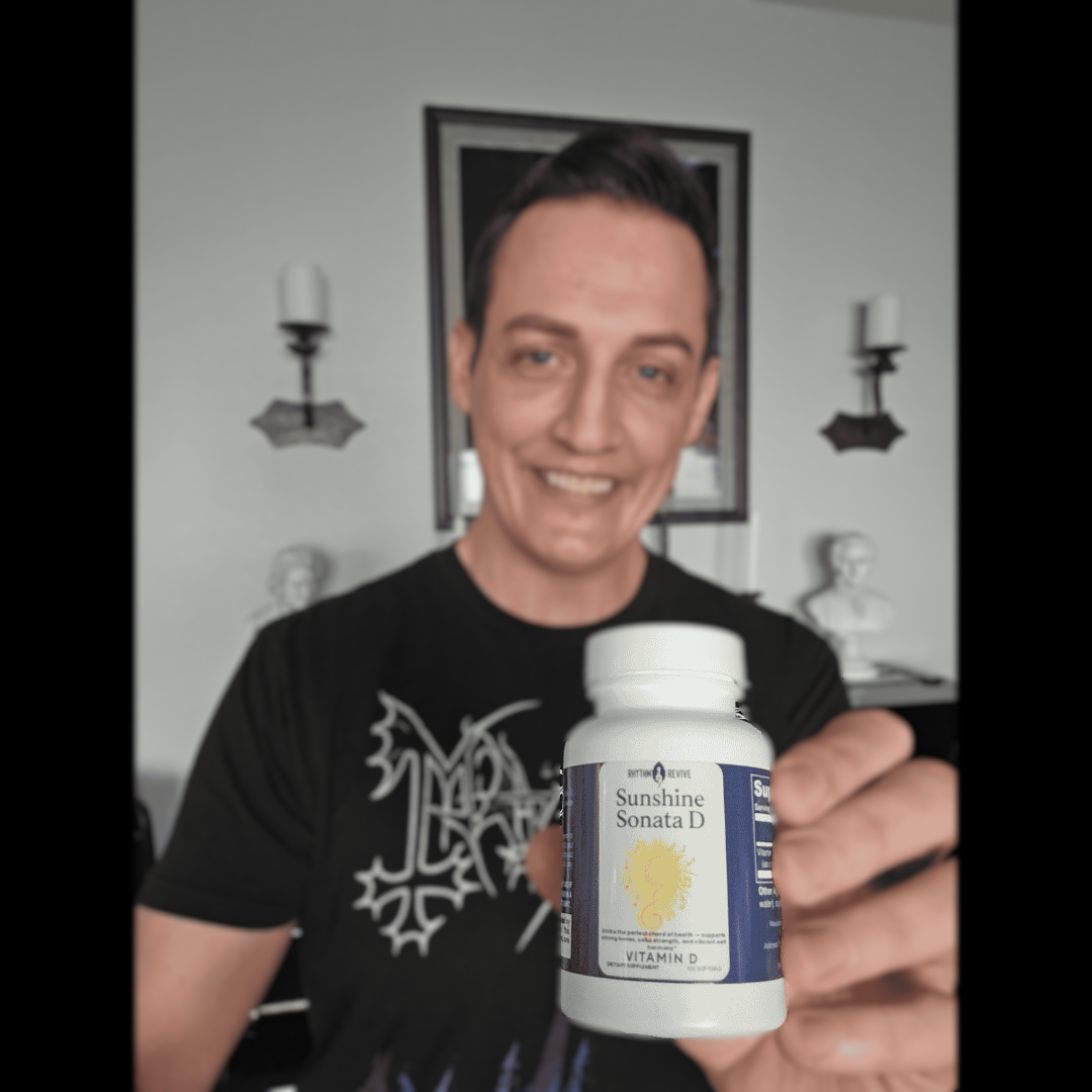 Person holding a Sunshine Sonata Vitamin D supplement bottle indoors.
