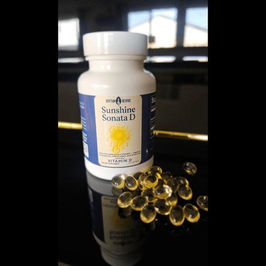 Bottle of Sunshine Sonata D vitamin D supplement with capsules on a reflective surface.